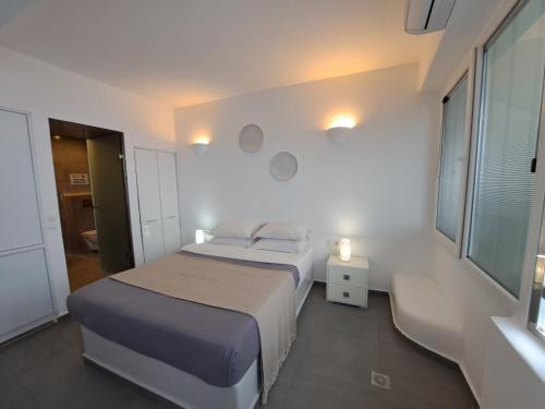 易莫洛林梦景套房酒店的白色的卧室设有床和窗户