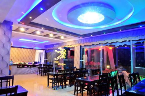 惹岛里宋中央酒店的一间带桌椅和大型天花板的餐厅