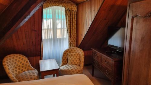 科尔普博斯特酒店的酒店客房设有两把椅子和电视