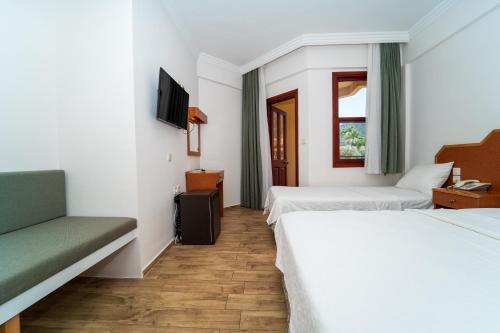 厄吕代尼兹贝尔塞汉海滩酒店的酒店客房,设有两张床和一张沙发