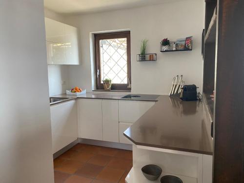 布里萨戈Brilago 6的厨房配有白色橱柜和台面