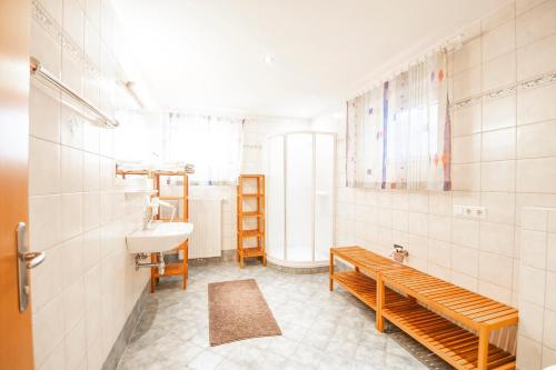 恩斯塔尔豪斯Ferienhaus Ennsling的一间带水槽、卫生间和长凳的浴室