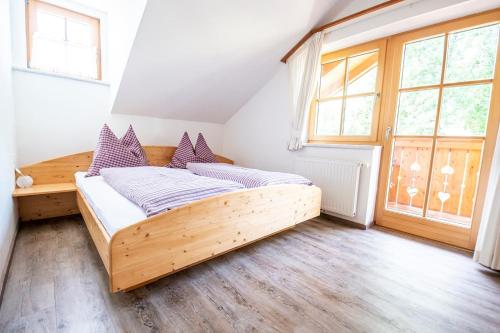 恩斯塔尔豪斯Ferienhaus Ennsling的一间卧室设有一张木床和一个大窗户。