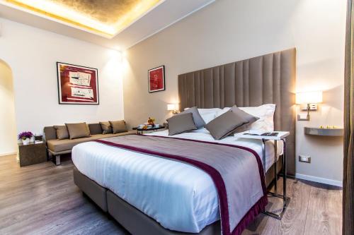 罗马Calisto Luxury Trastevere的酒店客房设有一张大床和一张沙发。