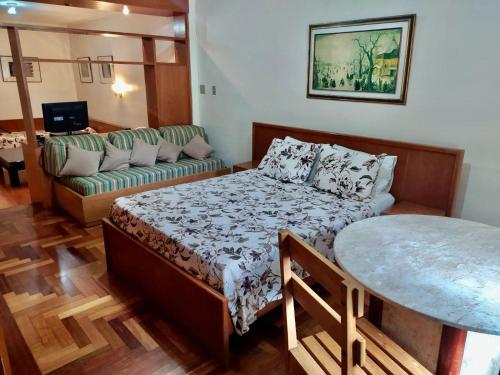 圣保罗都柏林酒店的一间卧室配有一张床、一张沙发和一张桌子