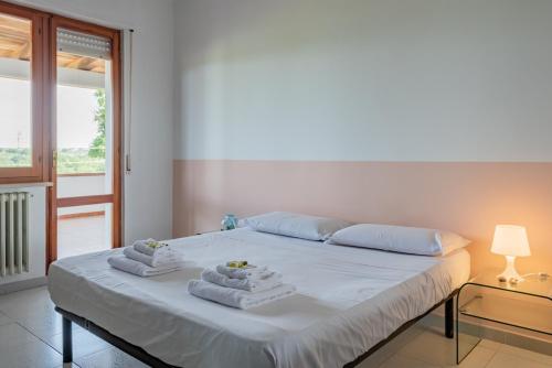 罗卡圣焦万尼La finestra sugli ulivi - YourPlace Abruzzo的卧室配有白色床和毛巾