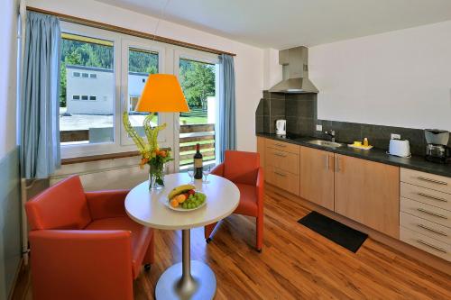 达沃斯索拉利亚酒店式公寓的厨房配有一张桌子,上面放着一碗水果