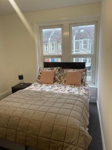 布里斯托Lovely room in Bristol 5的一间卧室设有一张大床和两个窗户