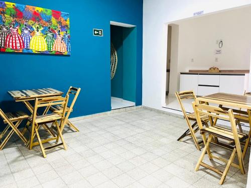 萨尔瓦多Hostel Recanto da Paciência的配有桌椅和蓝色墙壁的房间