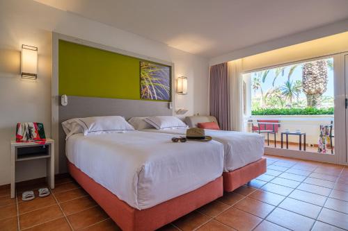 拉皮内达Oassium Hotel - Adults Only的一间卧室设有一张大床和一个大窗户