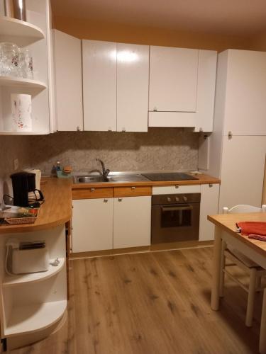 卡尼洛瑞维拉Sunshine GuestHouse的厨房铺有木地板,配有白色橱柜。