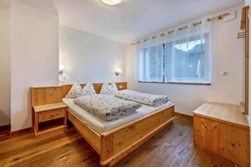 马兰扎Maurerhof Morgenrot的一间卧室设有一张木床和一个窗户。