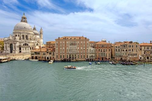 威尼斯The Gritti Palace, a Luxury Collection Hotel, Venice的水面上乘船的城市景观