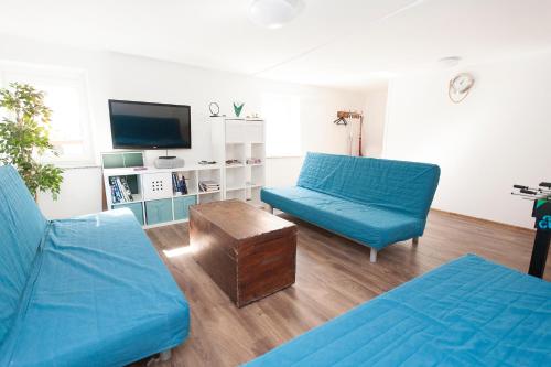 皮兰Sailing House Piran的客厅配有2张蓝色沙发和电视