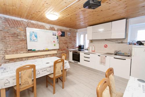 皮兰Sailing House Piran的厨房配有桌椅和白色的柜台。