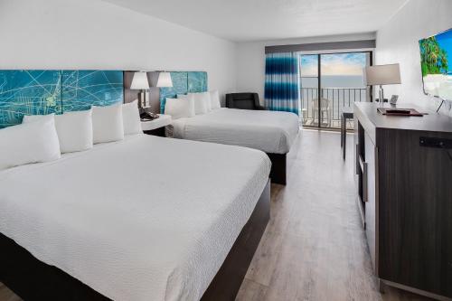 默特尔比奇热带海洋酒店 的酒店客房设有两张床和一个阳台。