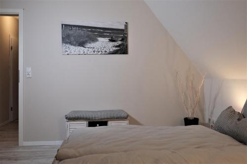 格洛米茨FEWO Ostseeland的白色卧室配有床和凳子