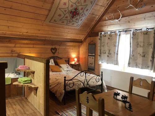 奥尔贝Chambre d'hôtes Carélie et Laponie的小木屋内一间卧室,配有一张床