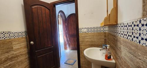 马萨阿拉姆Rayhana Guest House的一间带水槽、镜子和门的浴室