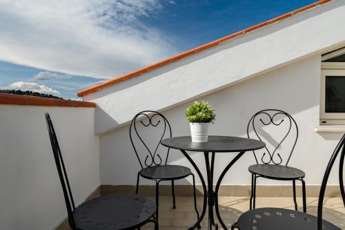 滨海弗兰卡维拉I fiori del mare - YourPlace Abruzzo的天井配有两把椅子和一张桌子及盆栽植物
