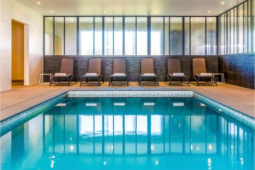 尼乌波特Holiday Suites Nieuwpoort的一个带椅子的酒店客房游泳池