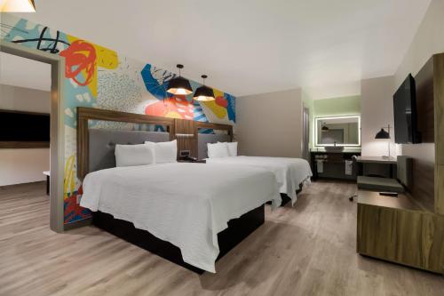 休斯顿Signature Inn Houston Galleria的酒店客房设有两张床和一台平面电视。