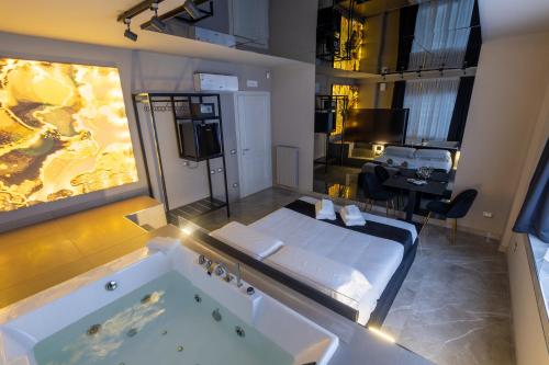 巴勒莫Maximum Exclusive Suite & Spa的带浴缸的浴室和带桌子的客房