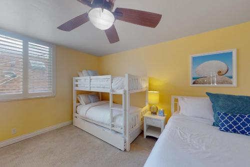 圣地亚哥Devon Retreat Unit D的卧室配有白色双层床和吊扇