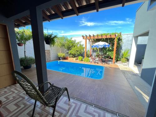 博尼图Aconchego e tranquilidade 1的庭院设有游泳池、两把椅子和一把遮阳伞