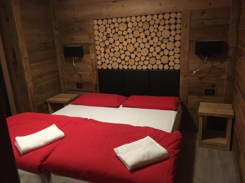 帕苏德尔托纳莱Appartamenti Miriam的一间卧室配有一张带红色床单和枕头的床。
