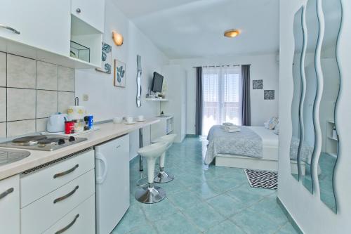 赫瓦尔安尼塔公寓式旅馆的一间厨房,配有白色的橱柜和一张位于客房内的床