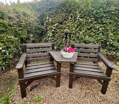 格里姆斯比Prelude Guesthouse, Brigsley Grimsby的木桌和长凳上放着一碗鲜花