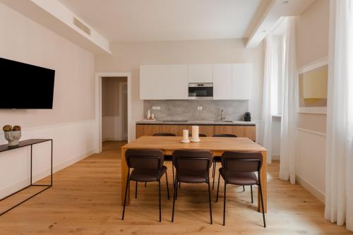 罗马Sonder Antinoo的厨房以及带木桌和椅子的用餐室。