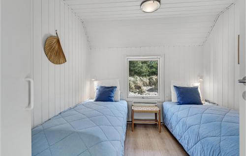 布拉万德Stunning Home In Blvand With 4 Bedrooms, Sauna And Indoor Swimming Pool的白色客房的两张床,配有蓝色枕头