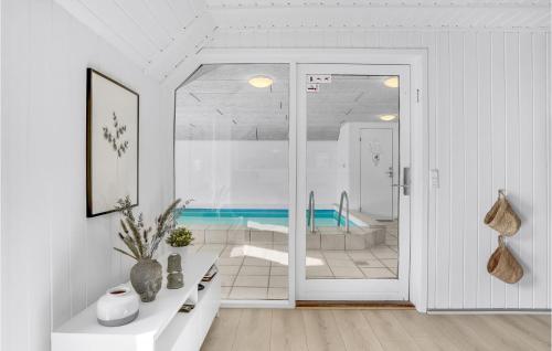 布拉万德Stunning Home In Blvand With 4 Bedrooms, Sauna And Indoor Swimming Pool的白色的浴室设有浴缸和玻璃门