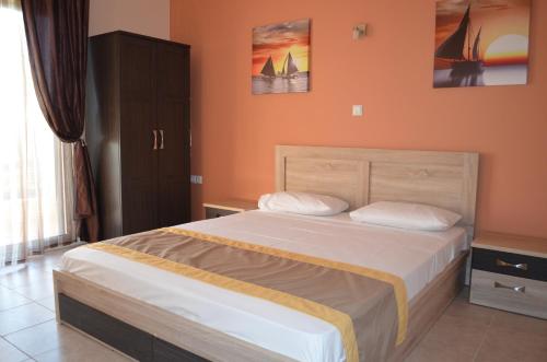 利迈纳里亚Thassos Grand Villas Apartments & Studios的一间卧室配有一张带橙色墙壁的大床