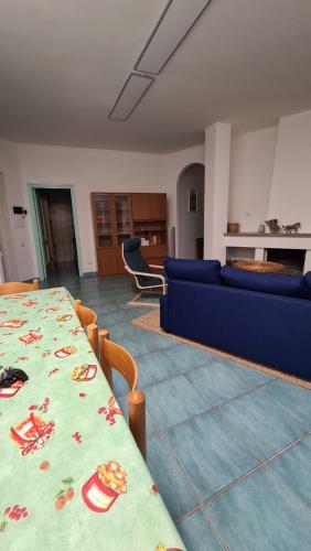 帕利努罗Villa Palinuro的客厅配有桌子和蓝色沙发
