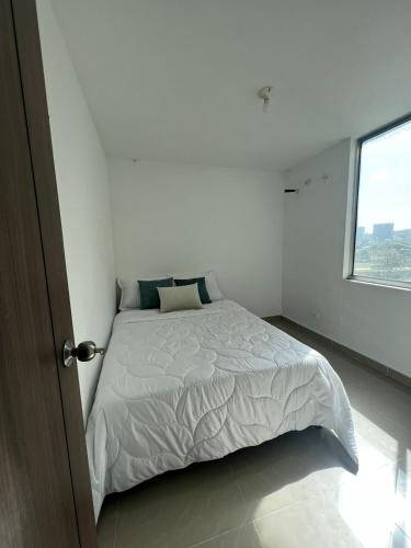 哥伦比亚港apartamento barranquilla villa campestre!的白色的卧室设有床和窗户