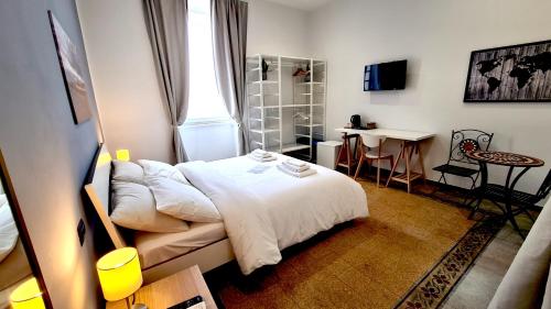 锡拉库扎Fortuna Guest House的卧室配有白色的床、桌子和书桌