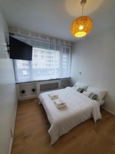 叙雷纳Apartment 2 or 3 bedrooms near Paris的卧室配有白色的床和窗户。