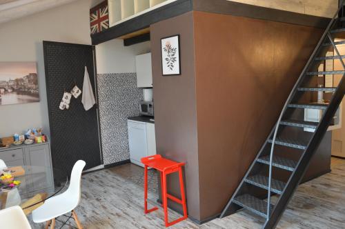 库尼奥La petite maison de Claire的带红色凳子的厨房内的一张高架床