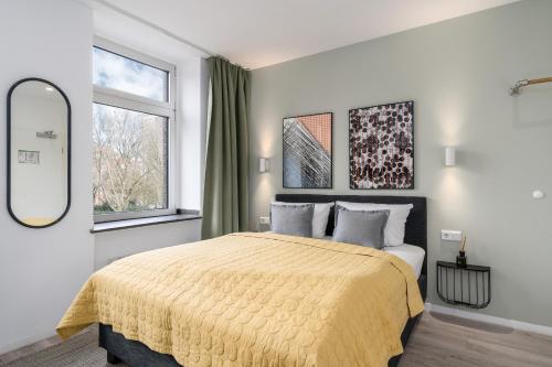 多特蒙德BRIGHT Dortmund City Center的一间卧室配有一张带黄色毯子的大床