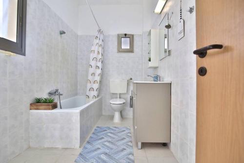 海法Breeze” luxury apartment”的带浴缸、卫生间和盥洗盆的浴室