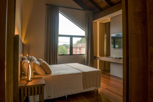 格拉玛多普萨达卡斯特酒店的一间卧室设有一张床和一个大窗户