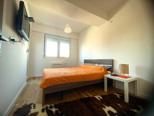 库马诺沃Apartman Nikol的一间卧室配有橙色的床和窗户。