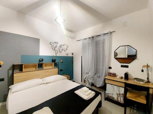 卡梅罗塔码头Don Mario Aparthotel & Rooms的一间卧室配有一张大床和镜子