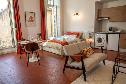 诺沃Superbe appartement de charme à 10mn de Saint-Rémy的一间卧室配有一张床铺和一张桌子,还设有一间厨房