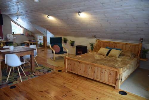 库尔迪加Čučumuiža的一间卧室配有一张大床和一张桌子及椅子
