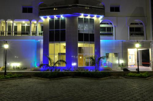 科托努Benin Royal Hotel的一座晚上有蓝色灯光的建筑