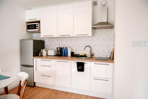济夫努夫Golden Port SPA - Easy-Rent Apartments的白色的厨房配有白色橱柜和冰箱。
